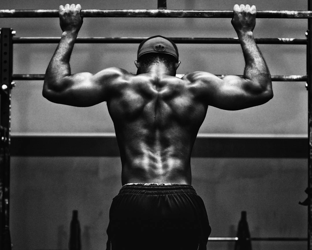 Photo noir et blanc d'un homme faisant des tractions vue de dos