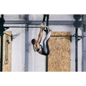 femme s'entrainant avec les Anneaux de musculation décathlon dans salle de cross fit