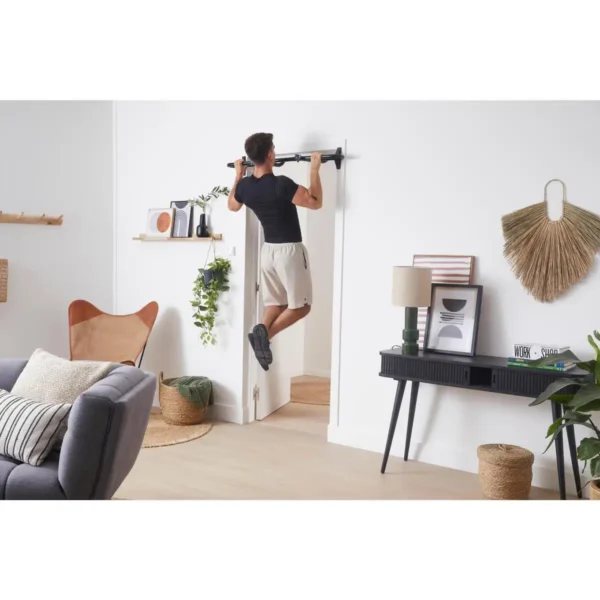 Homme faisant des tractions sur une barre de tractions sans fixation pour cadres de portes