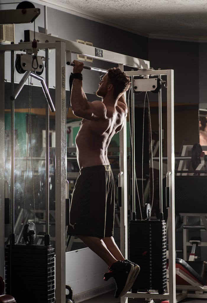 Hommes faisant des tractions en salle de sport sur barre de tractions