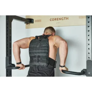 Homme faisant des dips lestés avec le rack mural de musculation pliable Corength decathlon et le gilet lesté 10kg dans son garage