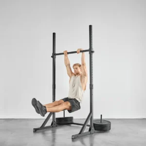 Barre de traction Eric Flag Slide bar 2.0 - Eric flag faisant des muscle up avec la barre en position basse et des disques de leste placés sur les colonnes de stabilisation