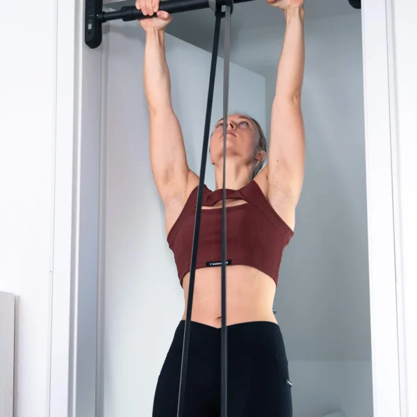 Barre de Traction de Porte Extend-it Gornation - Femme faisant des tractions assistées avec élastique de musculation