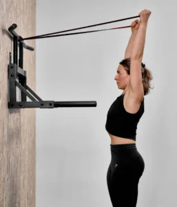 Femme utilisant des élastiques de musculation avec la barre de traction murale Eric Flag